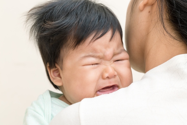 泣き止まない子供をあやす保育士