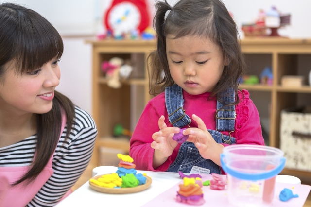 室内遊びをする子供と保育士