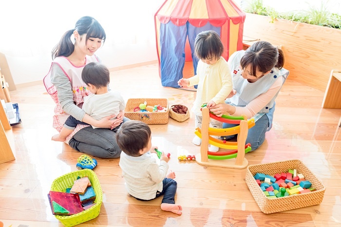 認証保育園で3人の子供と遊ぶ2人の保育士