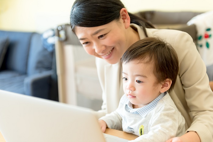 子どもとパソコンを見る女性